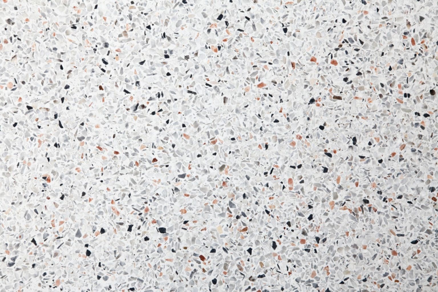 Lys terrazzo med små sorte, røde og grå sten set oppefra