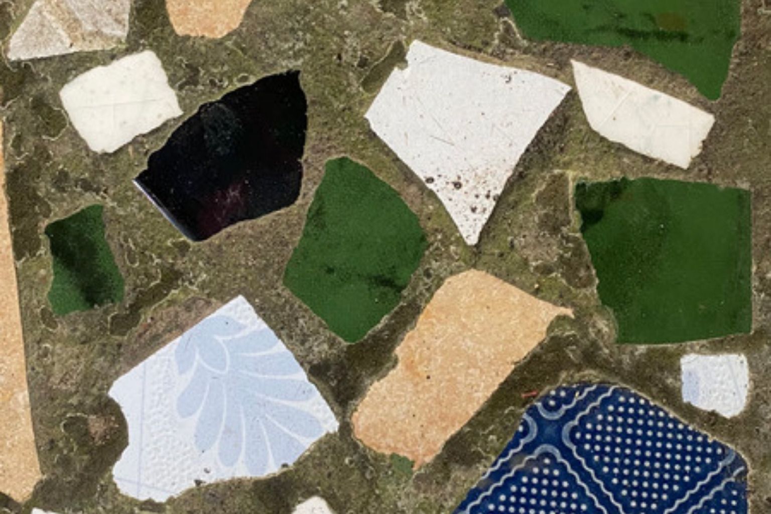 Nærbillede af terrazzo med store stenstykker i grøn, hvid og beige